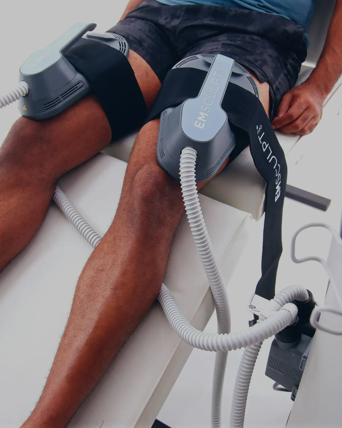 Man having Emsculpt NEO muscle-building treatment on his thighs at Skin Story Clinic, London